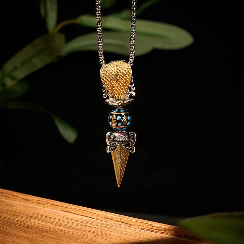 Handmade Tibetan Buddhist necklace pendant with woven gold top bead, enamel middle section, sharp vajra spike, and traditional craftsmanship details