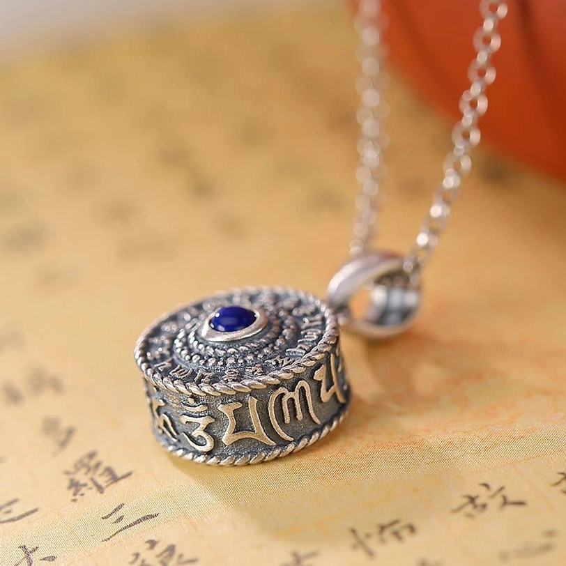Side overhead view of 925 Sterling Silver Om Mani Padme Hum pendant showing cylindrical profile with engraved mantras around the rim and lapis lazuli stone on top