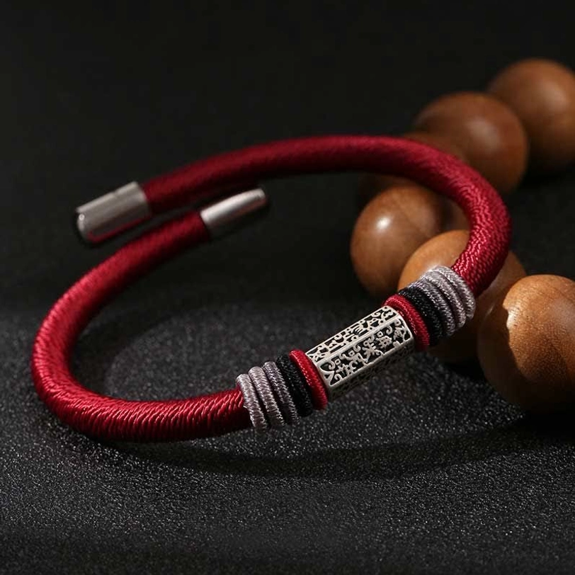 Red Om Mani Padme Hum sterling silver bracelet with engraved charm and wooden prayer beads on black backdrop