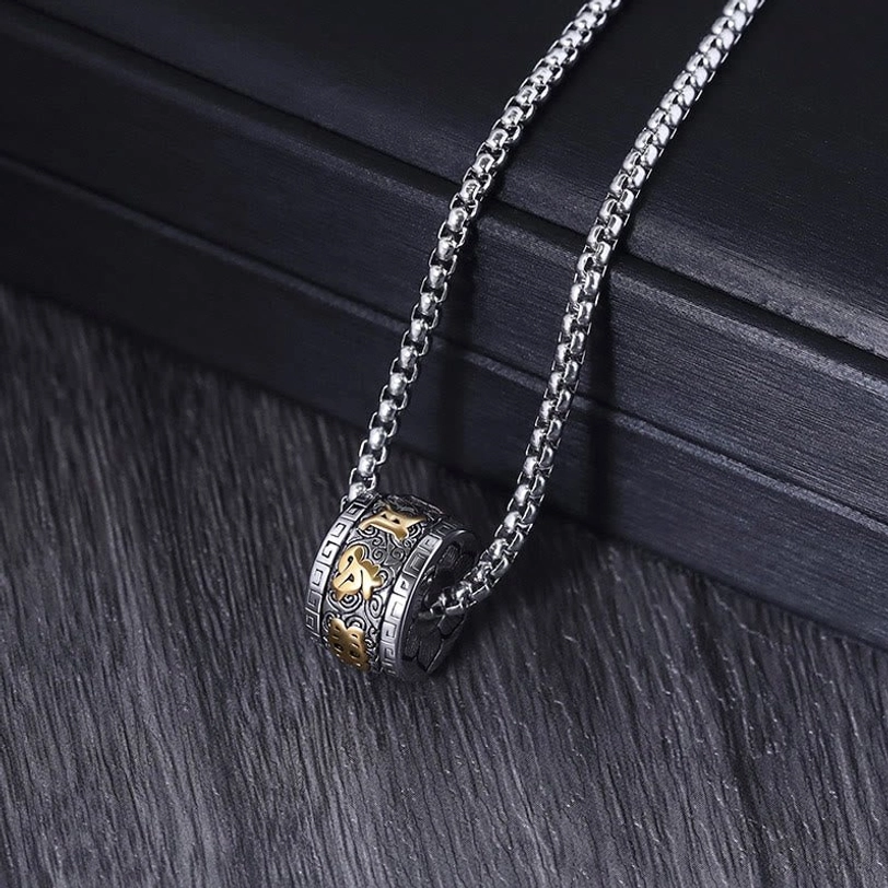 All-silver Om Mani Padme Hum mantra necklace with engraved barrel pendant and wheat chain displayed on dark wooden table with presentation box