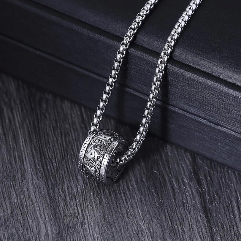 Om Mani Padme Hum plain engraved silver barrel pendant necklace with wheat link chain angled side view on black background