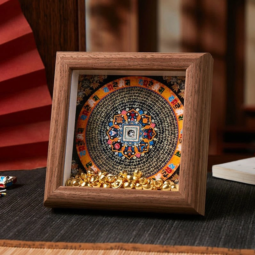 Tibetan spiritual thangka frame with black-background circular mandala and golden ingot embellishments on dark brown wood
