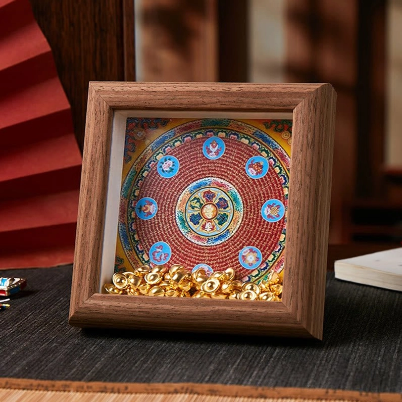 Tibetan thangka sacred mantra frame with vibrant circular mandala design and golden ingot accents on dark brown wood frame
