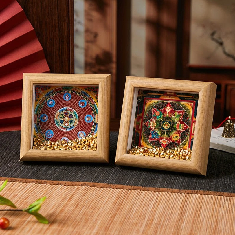 Sacred thangka frame close-up showing resin finish, mandala details, and golden ingot ornaments in natural lighting