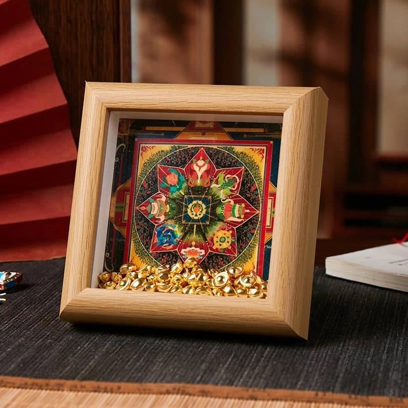 Spiritual thangka frame displaying hexagonal floral mandala pattern with golden ingot accents on light wood background