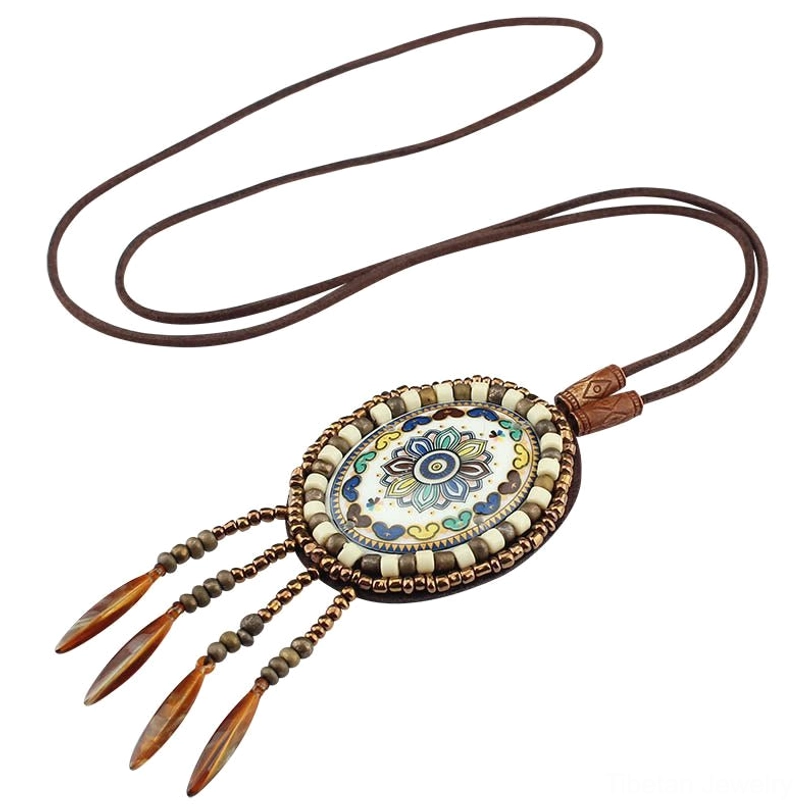 Pastel mandala style beaded pendant necklace with brown leather tassels on simple leather cord, top-down view