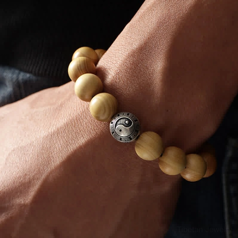 Peach wood bracelet worn on wrist in daily lifestyle setting - side view of bagua silver bead spacer