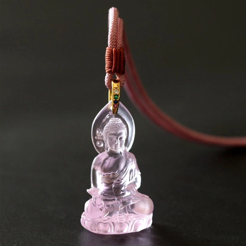 Pink Medicine Buddha Liuli crystal pendant close-up detail, compassion-symbolizing rose tone with Buddha carving and lotus base visible