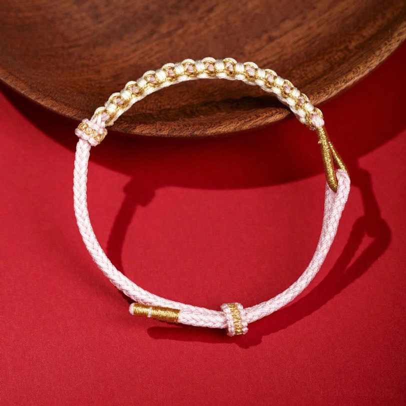 Light pink Tibetan peach blossom braided bracelet with gold metal ends and knot details