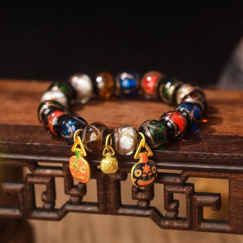 Flat Orange-Black Gold Pixiu Family Charm bracelet close-up front view featuring one oval enamel charm and two gold pendants with mixed glossy glass beads