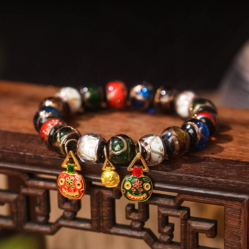 Flat Red-Green Gold Pixiu Family Charm bracelet close-up front view with two gold bell pendants, one round enamel charm, and vibrant mixed Liuli glass beads