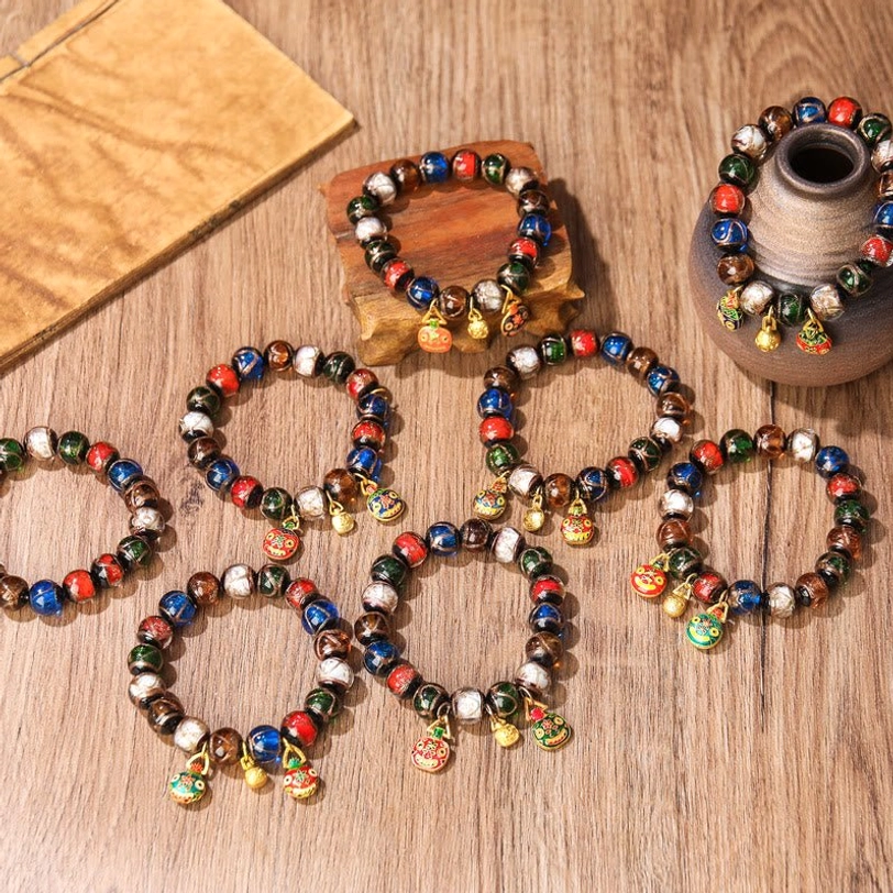 Five Elements Gold Pixiu Family Charm bracelet close-up front view with two enamel pendants, two gold pendants, and rich mixed colored Liuli glass beads