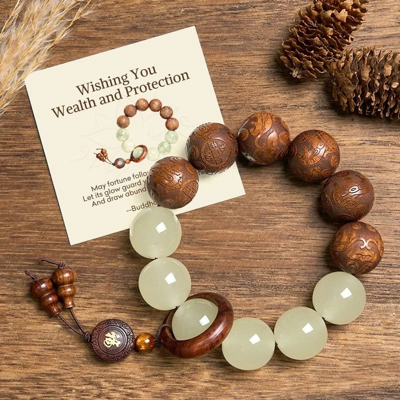 Sappan wood pixiu fu bracelet with pale green jade beads displayed on wooden table with pine cone decor, shown with prosperity gift message card