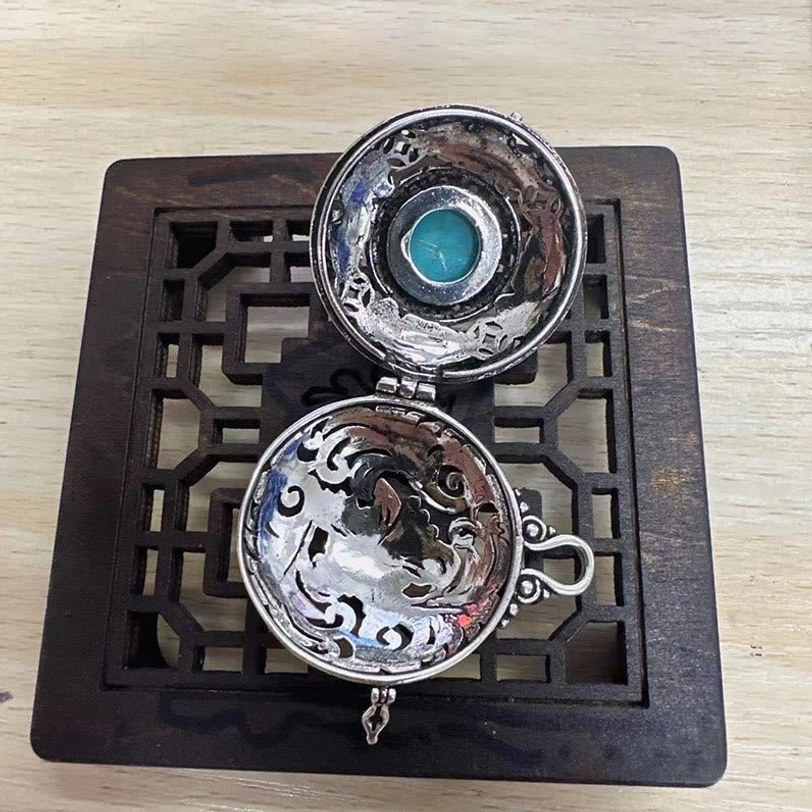 Tibetan copper Pi Xiu locket interior - hollow compartment structure showing hinged mechanism and craftsmanship