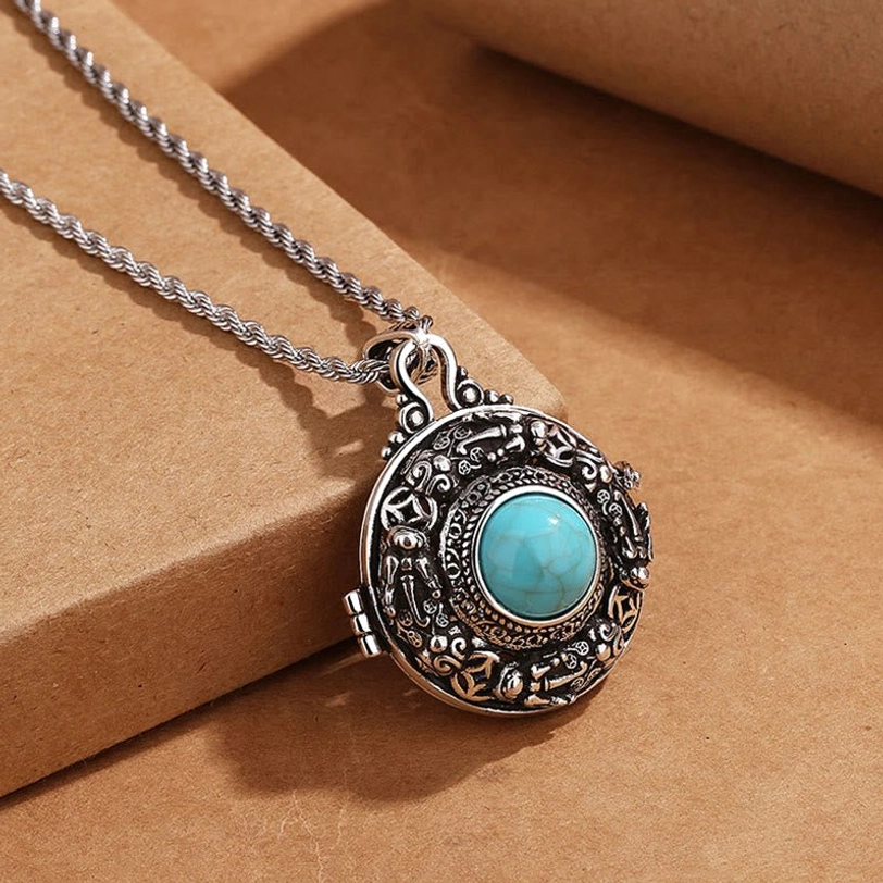 Tibetan Pi Xiu copper necklace three-quarter view - showing round hinged locket design with engraved ethnic details