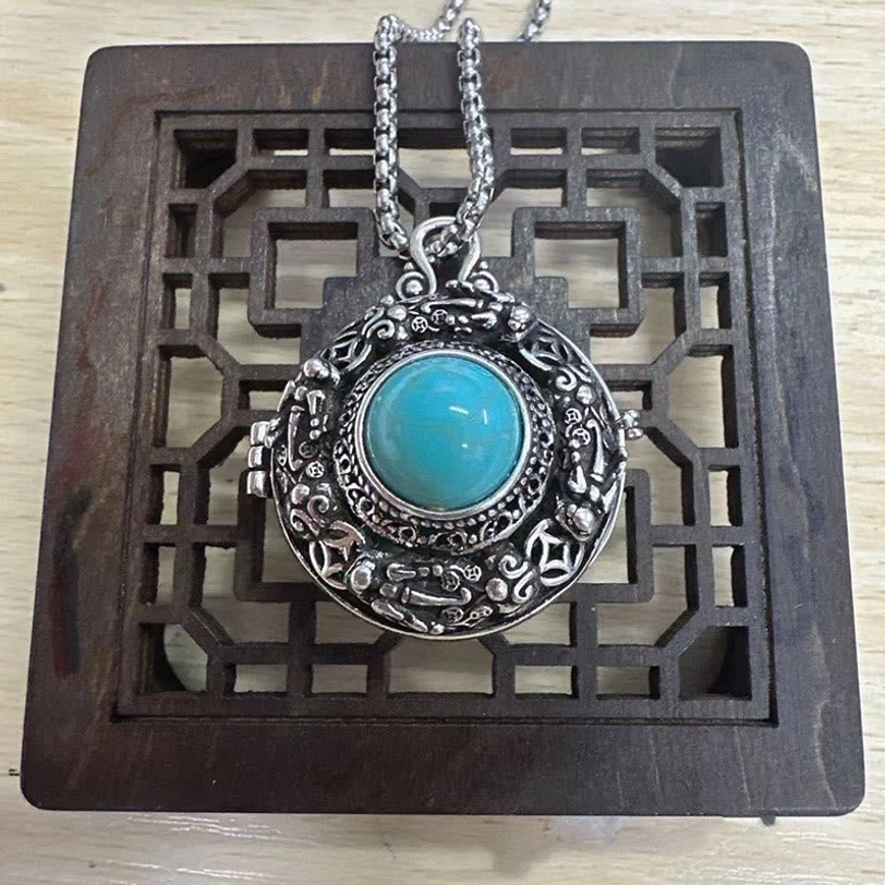 Pi Xiu necklace with pearl chain - tabletop display against carved wooden frame background