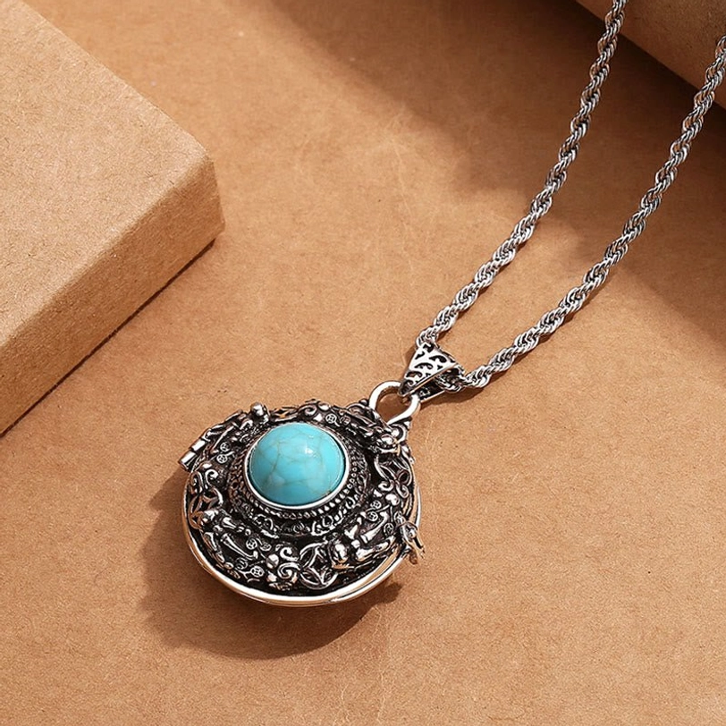 Tibetan Pi Xiu copper necklace with twisted chain - angled overhead view showing intricate carving detail and turquoise stone accent