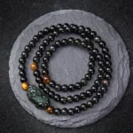 Pixiu Rainbow Obsidian Black Obsidian wealth protection bracelet with carved Pixiu charm and tiger eye spacer beads overhead view