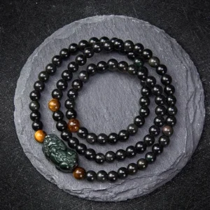 Pixiu Rainbow Obsidian Black Obsidian wealth protection bracelet with carved Pixiu charm and tiger eye spacer beads overhead view