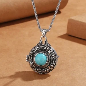 Pi Xiu wealth guardian pendant closeup - front view displaying embossed Tibetan patterns and central turquoise gemstone
