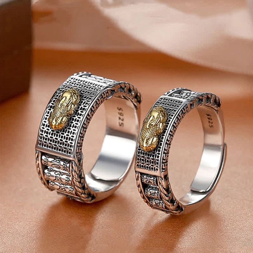 Gold-plated Pixiu prayer wheel couple rings with rotating carved textures and S925 silver inner stamps on leather desktop