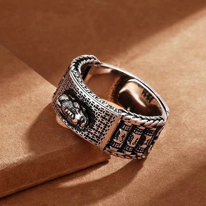 Pixiu wealth ring top-down close-up with embossed design, twisted rope border and open-ended adjustable band