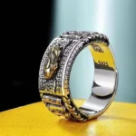 Pixiu wealth prayer wheel ring side-view close-up with embossed dragon design and S925 silver stamp on black display background
