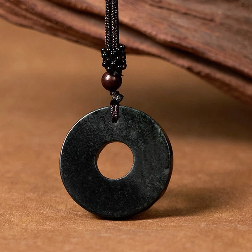 Plain smooth black-green jade peace buckle pendant showing polished circular donut shape with wooden accent bead