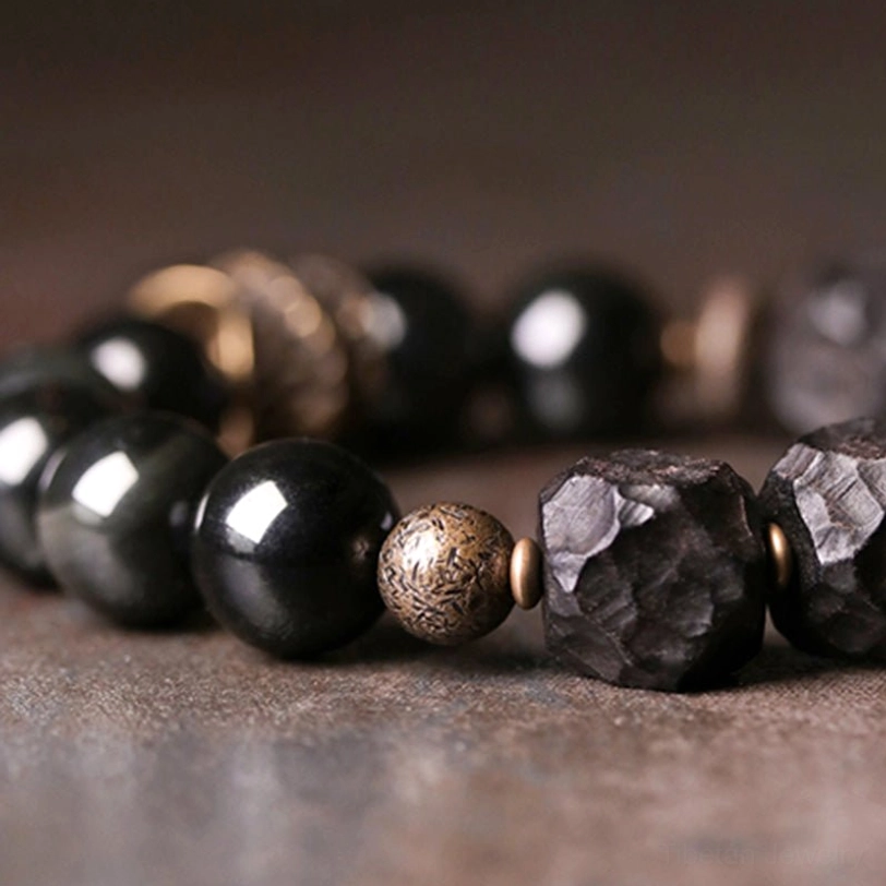 High-luster polished round black obsidian beads with subtle iridescent sheen macro photography
