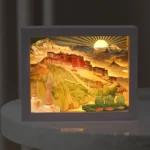 Potala Palace 3D paper carving LED table lamp with warm yellow light, front view showing intricate architectural details and layered design