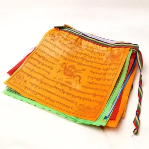 Folded Tibetan prayer flags with striped ribbons side view layered colored fabric