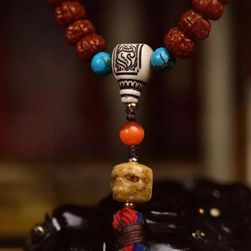 Lower section of 108 Bodhi seed prayer mala with carved guru bead, turquoise accents, agate bead, wooden pendant, and colorful tassel
