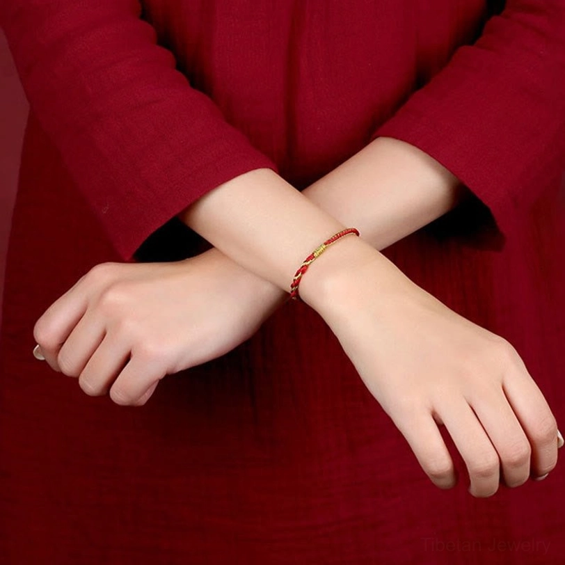 Side close-up detail of Tibetan braided bracelet showing knot and gold-tone terminal accent