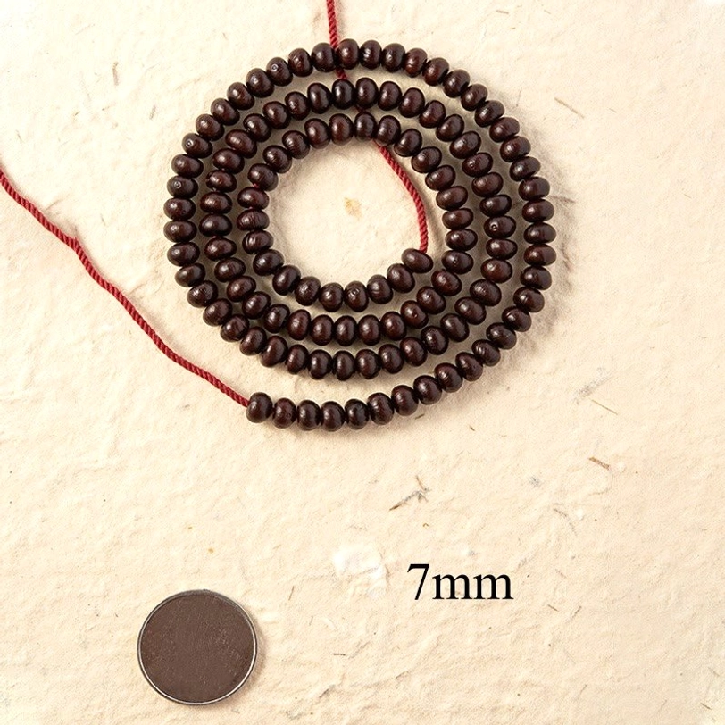 7mm Purple Bodhi Seed mala beads size comparison with coin and size label showing small round beads