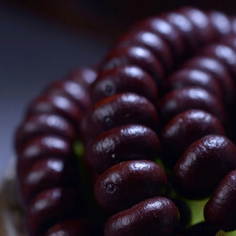 Flat lay close-up of smooth dark reddish-brown Purple Bodhi Seed beads tightly bundled