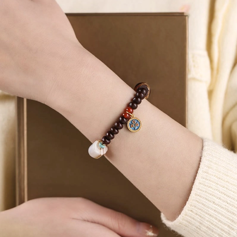 Bodhi seed Dzi bead bracelet worn on wrist showing daily wear styling with enamel charm and gold spacer beads