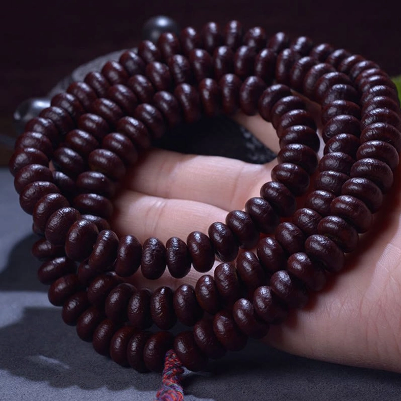 Purple Bodhi Seed 108 mala beads in hand - dark reddish-brown authentic prayer beads with red tassel