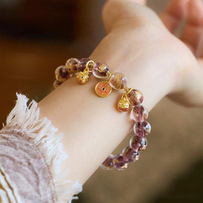 Purple and brown two-tone liuli glass fortune bracelet with gold Pi Xiu lucky charms, wrist view