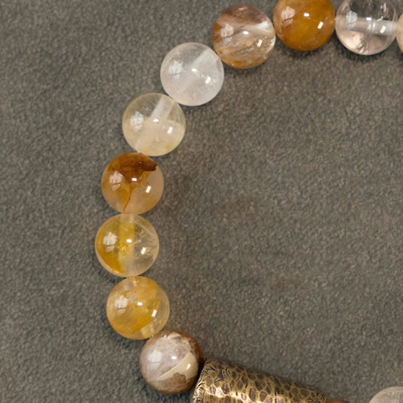 Woman wearing purple phantom quartz bracelet on wrist, spiritual healing jewelry lifestyle photography