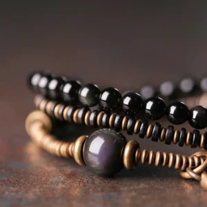 Close-up side view of layered rainbow obsidian beaded strands with bronze spacers and wooden beads