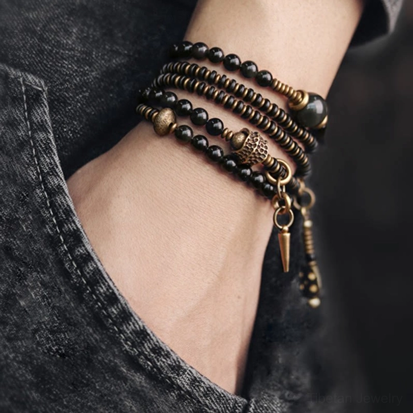 Rainbow obsidian ebony wood bracelet worn on wrist with denim background - lifestyle wearing perspective