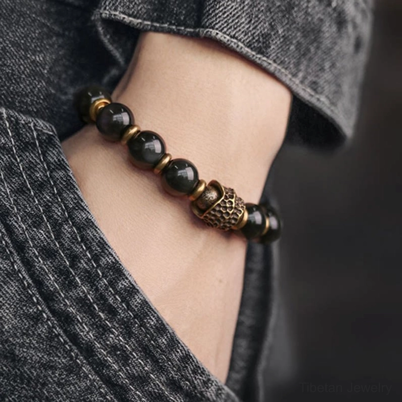 Rainbow obsidian copper bracelet worn on wrist with denim fabric background casual daily wear