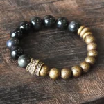 Rainbow Obsidian Copper Beaded Bracelet - Top View Flat Lay Showing Glossy Black Obsidian Beads with Vintage Bronze Metal Accents and Carved Connector