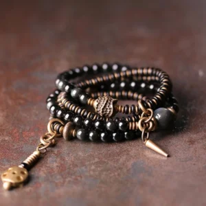 Rainbow obsidian ebony wood copper multilayer bracelet - main product view showing iridescent beads with antique bronze spacers on vintage desktop