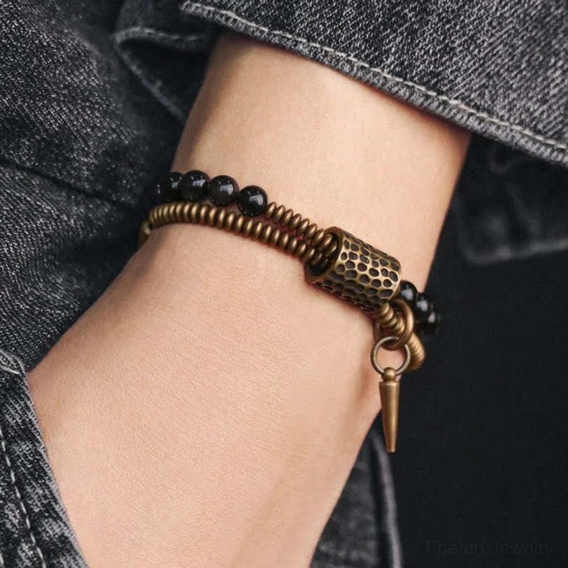 Rainbow Obsidian double layer bracelet worn on wrist with denim background, side angle view showing spike charm and layered design
