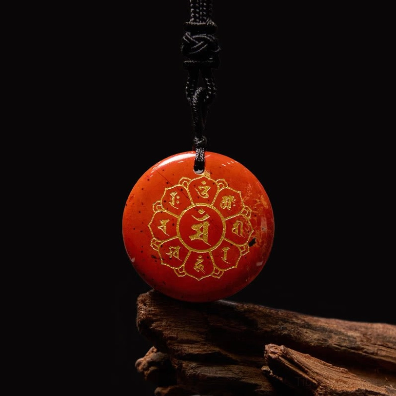 Red Agate Om Mani Padme Hum pendant with golden Sanskrit engraving on wooden background