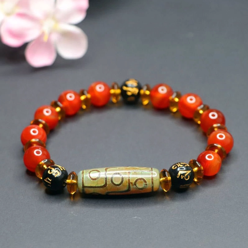 Red agate and nine-eye dzi bead bracelet close-up detail shot showing authentic bead texture, natural stone variations, and craftmanship quality