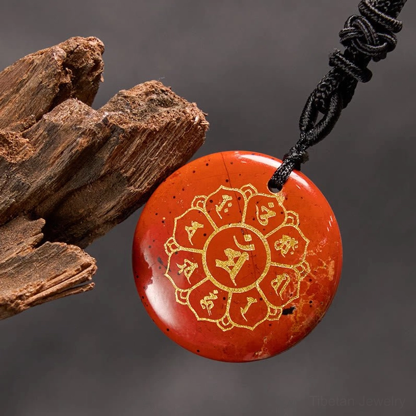 Red agate tibetan pendant close-up showing detailed mantra engraving and deep red stone color