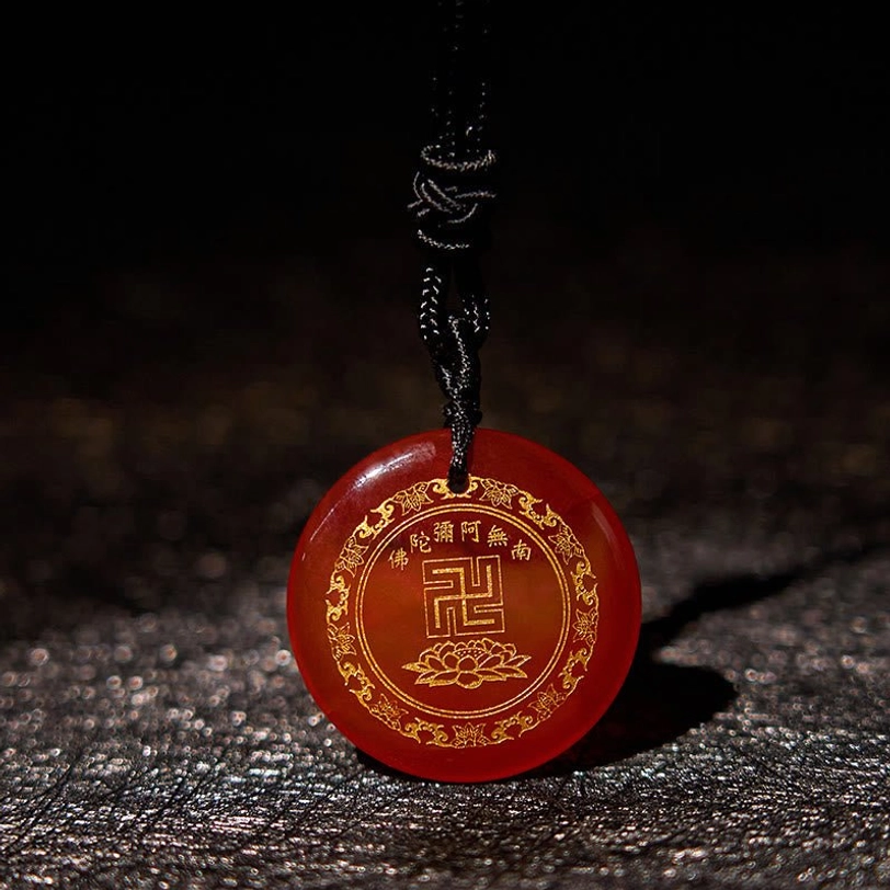 Red agate swastika lotus pendant close-up on dark background