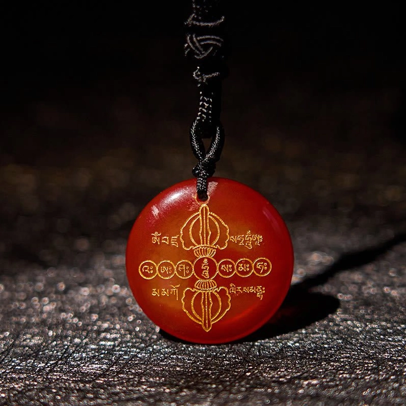 Red agate Vajra Dorje Tibetan necklace pendant with black braided cord and golden Sanskrit patterns